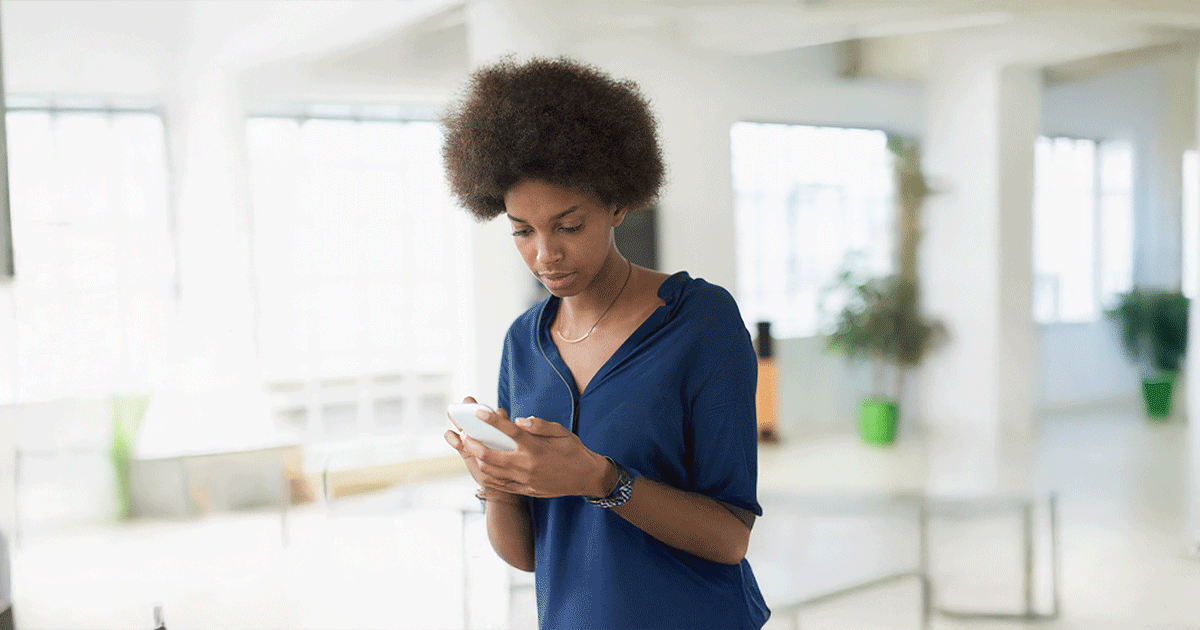 AdobeStock_383182491-blog Woman looking at her phone while researching pregnancy options after a positive pregnancy test.